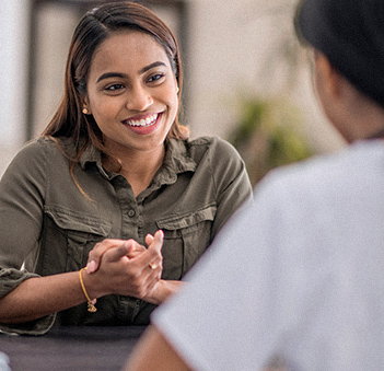 female patient smiling and talking to her primary care doctor