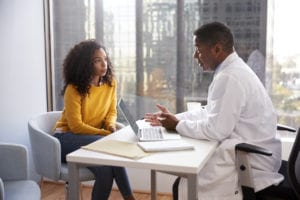 Serious Woman Having Consultation With Male Doctor In Hospital