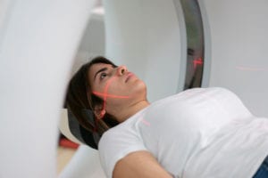 Young woman getting a brain scan at the MRI machine