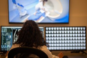 Doctor working on computer in magnetic resonance imaging control room