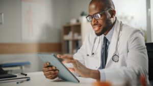 Primary care doctor checking patients report on tab