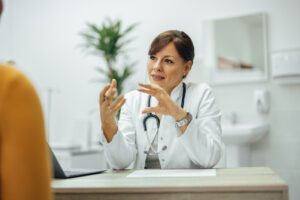 Primary Care Doctor gesturing while explaining something to a patient