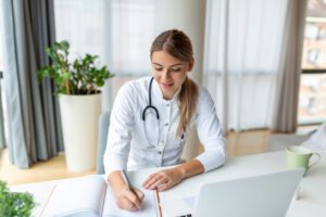 primary care doctor wearing uniform taking notes in medical journal