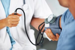 primary care doctor measuring blood pressure of patient