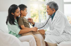 primary care doctor doing a checkup on a little boy at home