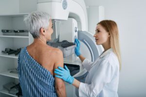 Senior woman having mammography scan at hospital with medical technician