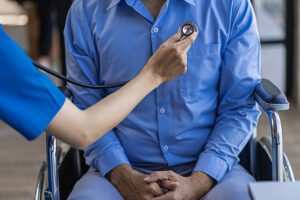 A female doctor gives advice and auscultation of the patient's heart with a stethoscope in a hospital