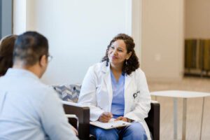 The mid adult female doctor listens attentively when she meets the unrecognizable couple for the first time.